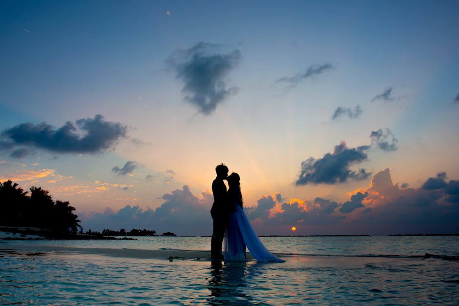 A barefoot beach ceremony at the water's edge during golden hour